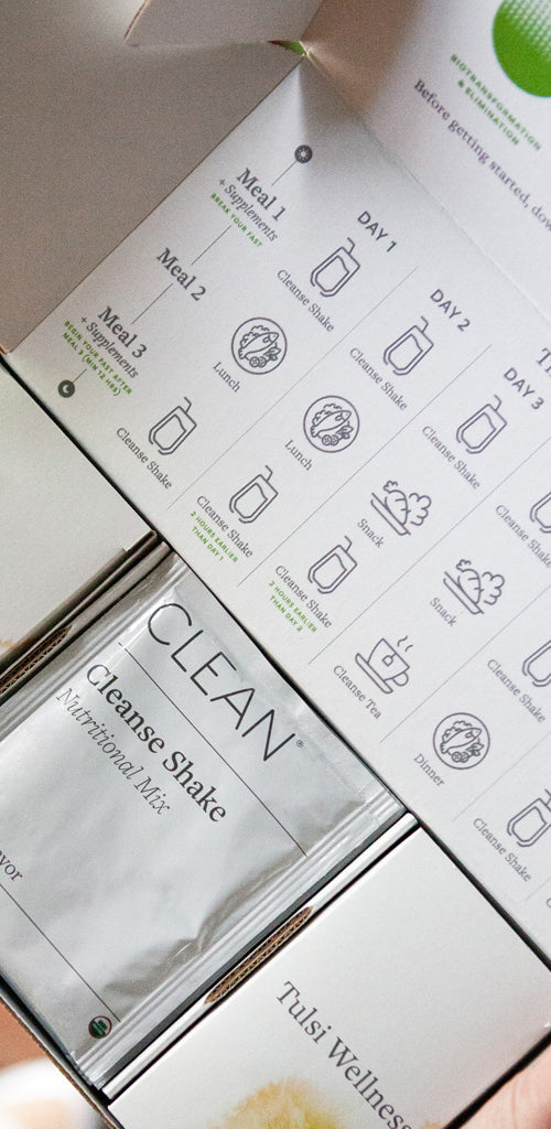Woman's hands holding a new, opened box of Clean 21 detox program.