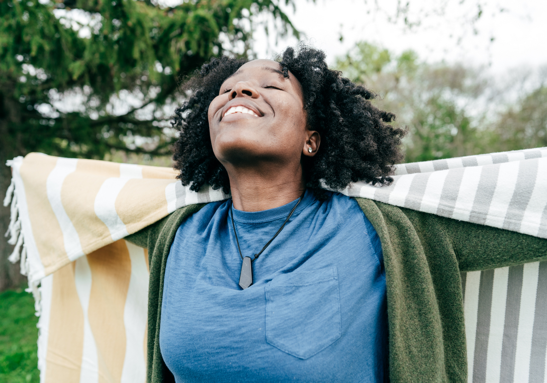 Woman outside wrapped in a blanket smiling