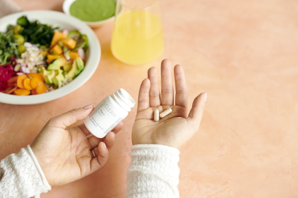 Person holding capsules from the clean digest bottle