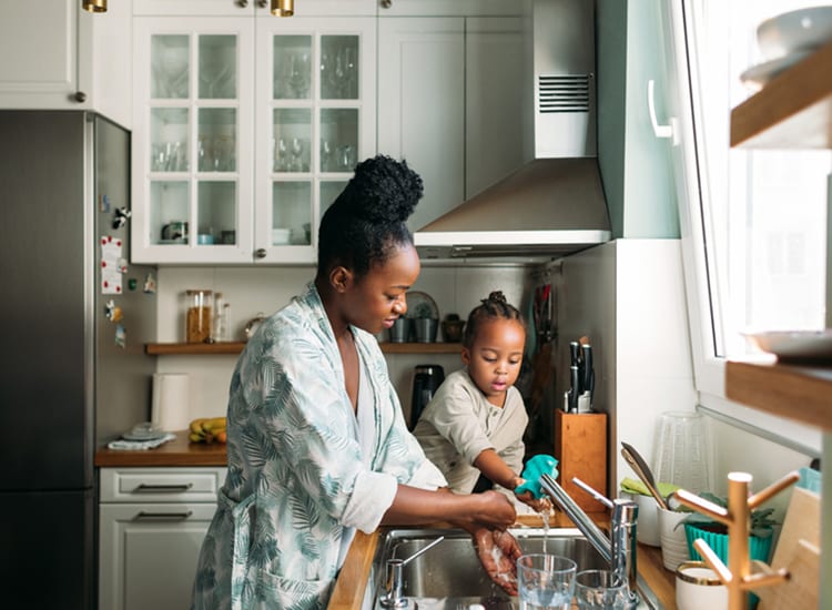 woman and daughter cleaning dishes in their kitchen