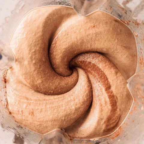 Close-up of a swirling chocolate and vanilla ice cream dessert in a container.