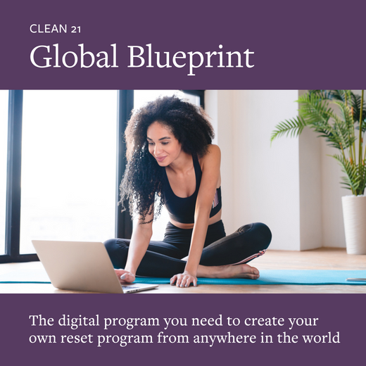 Promotional image for Clean 21 Global Blueprint featuring a woman sitting cross-legged on a mat with a laptop, indicating a digital wellness program for creating a reset program from anywhere in the world.