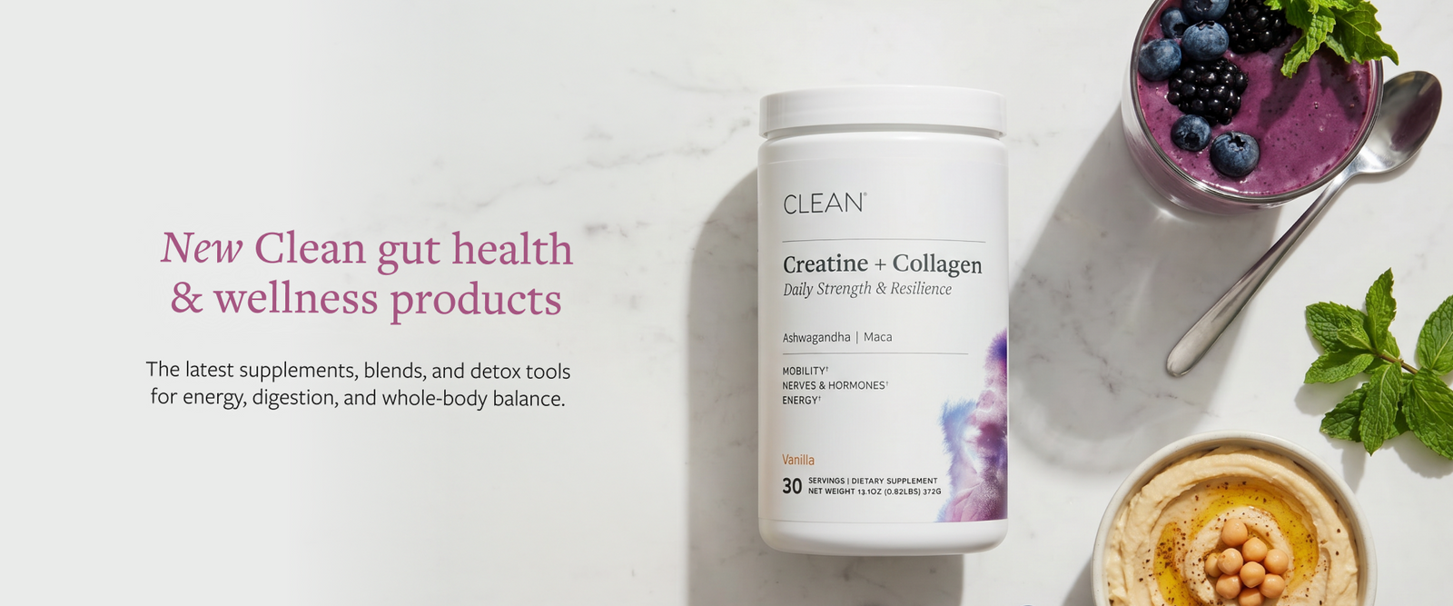 A white bottle of CLEAN Creatine + Collagen dietary supplement centered on a light marble surface, with wellness props including a purple smoothie, berries, mint, and a bowl of chickpeas around it. Text on the left reads 'New Clean gut health & wellness products.