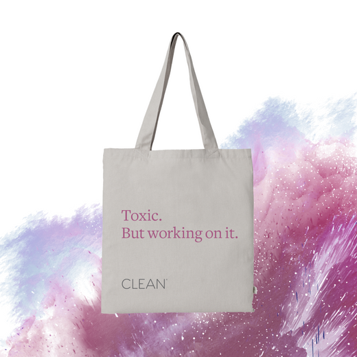 A gray tote bag with the text 'Toxic. But working on it.