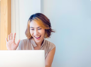 Woman happy and waving to a computer screen