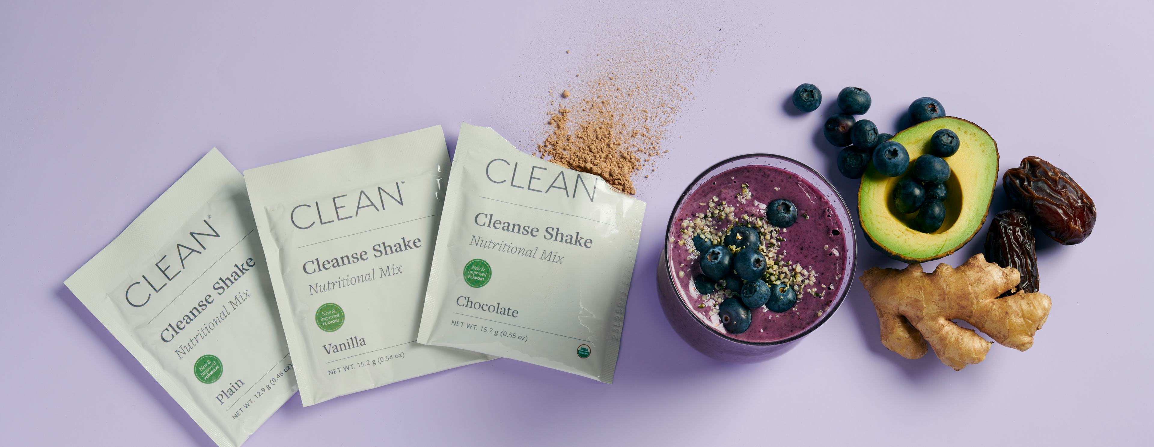 Clean Program Cleanse Shake packets next to a blueberry smoothie.