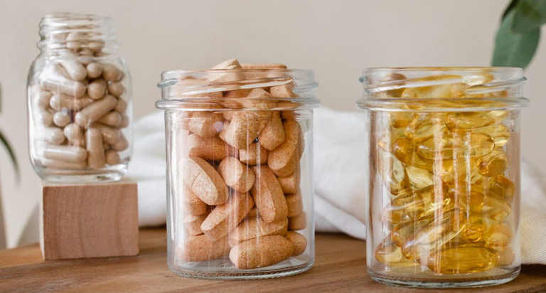 Glass jars on a table filled with natural supplements
